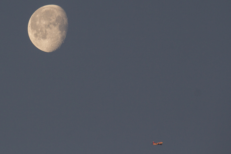 Ochtend maan met een vliegtuig