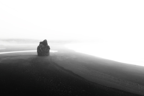 Zwarte strand in de mist