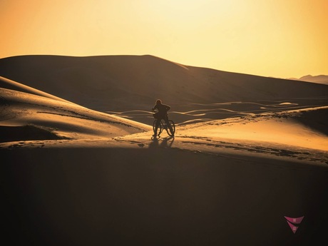 Fietser in woestijn van Merzouga