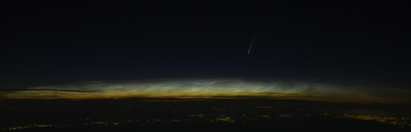 Komeet Neowise boven lichtende nachtwolken