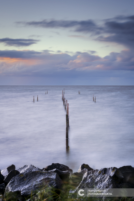 Visfuiken met houten palen in het IJsselmeer bij Zonsondergang