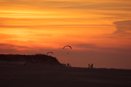 kitesurfers bij zonsondergang