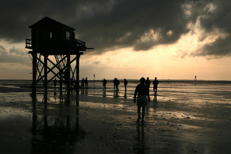 Tijdens een zeer vroege wadlooptocht op Engelsmanplaat dreven donkere wolken over het wad die de opkomende zon versluierden.