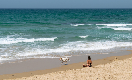 Vrouw mediteert op strand in Tel Aviv