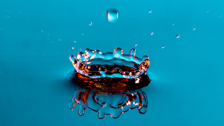 16x9 wallpaper of a waterdrop hitting a watersurface. Easy blue background