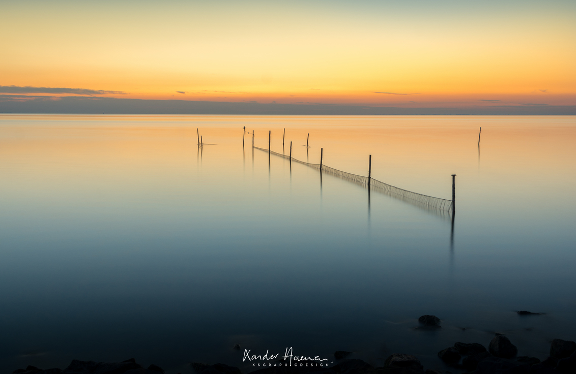 Rust op 't Markermeer - Geen wind op 't Markermeer, komt maar zelden voor. - foto door xsgraphicdesign op 25-10-2016 - deze foto bevat: zon, water, zonsondergang, spiegeling, landschap, meer, stenen, visnetten, lange sluitertijd