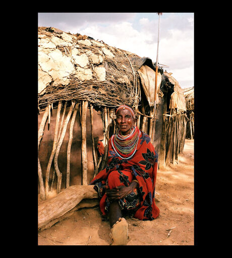 Oma voor haar hut in Kenia