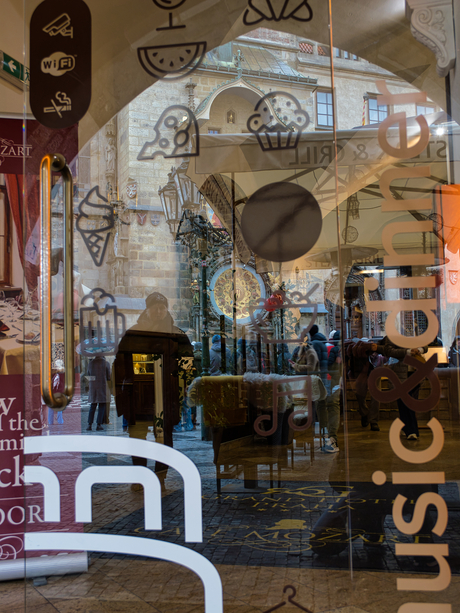 Reflectie van de astronomische klok in een glazen deur, Praag