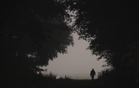 Une femme et son chien dans la brume.