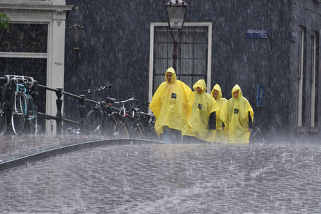 Toeristen in een regenachtig Amsterdam