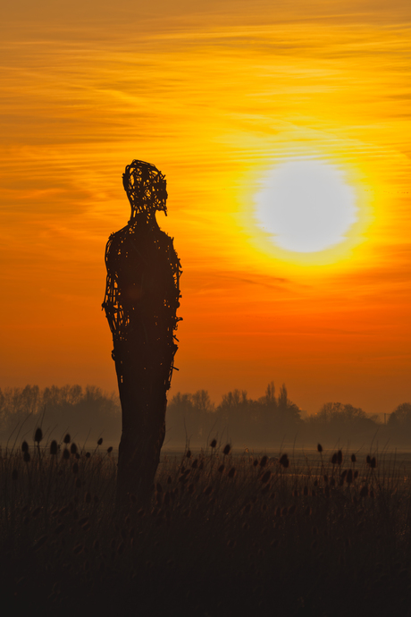 Silhouet van een mensfiguur in de zonopkomst