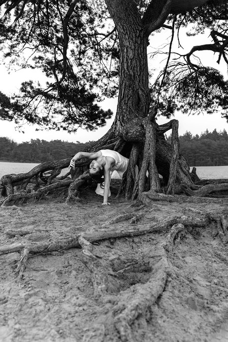 Like a tree - Uit de serie 'Like a tree'. De danseres wordt onderdeel van de omgeving. Geschoten in de Soesterduinen. - foto door elaine_hovenier op 05-02-2022 - deze foto bevat: zwartwit, buiten, boom, danseres, serie, lucht, hout, boom, kofferbak, natuurlijk landschap, takje, wereld, zwart en wit, gras, plant