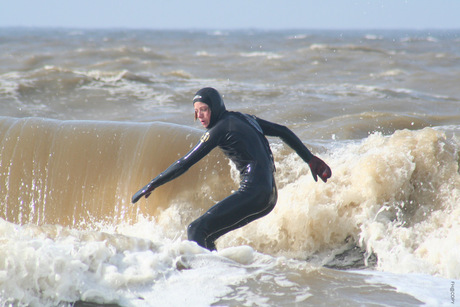 surfer op woeste golven te noordwijk aan zee