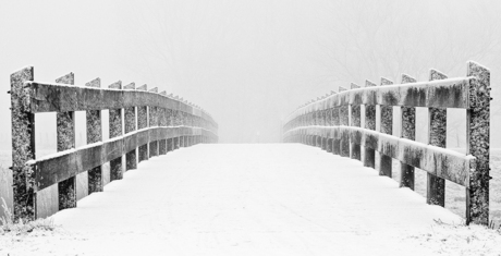 besneeuwde brug in de mist