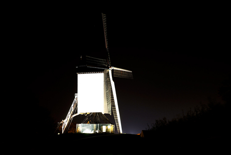 Witte molen bij zwarte nacht