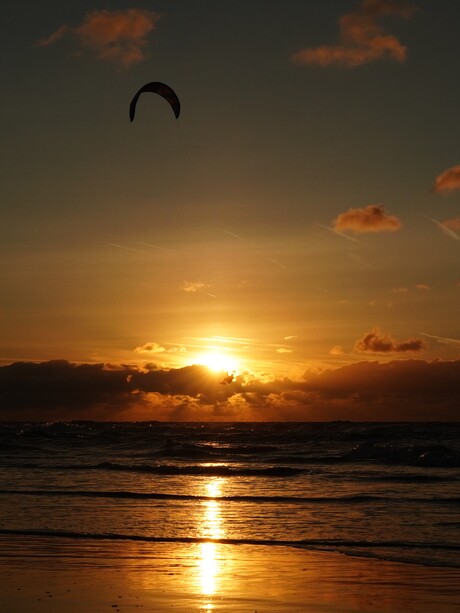 Kitesurfer als silhouet in de lucht