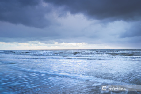 Stormwolken boven de horizon en de kust 