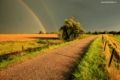 Regenboog op een mooi landweggetje