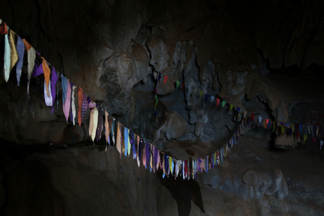 Boeddhistische vlaggetjes in donkere grot
