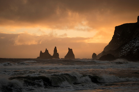 Prachtig uitzicht op de ruwe zee en de 'drie trollen' bij Dyrhólaey in IJsland net voor een enorme hagelbui losbarstte
