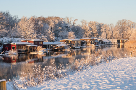 Zonsopkomst bij de woonboten in de sneeuw.