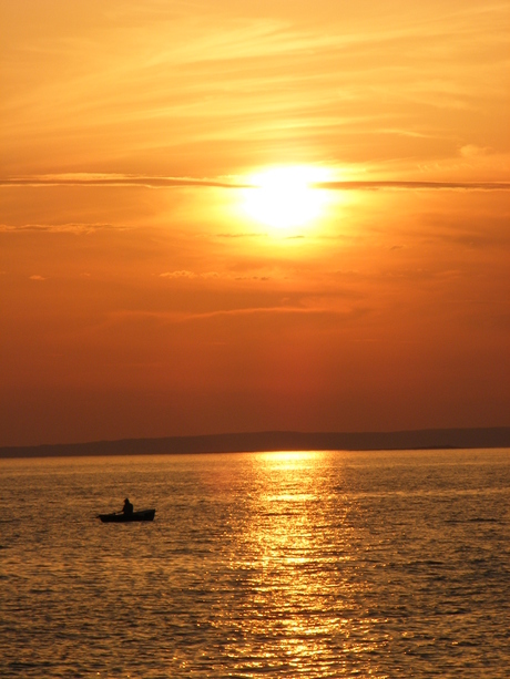 zonsondergang met man in boot