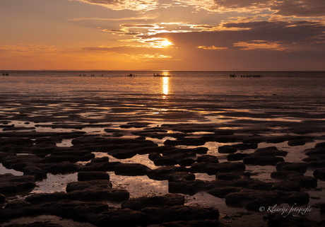 De zon gaat onder op het wad