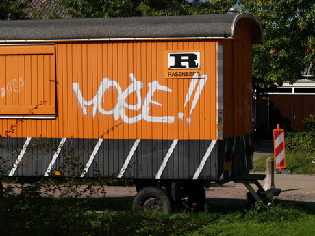 Mooie oranje bouwkeet met graffiti