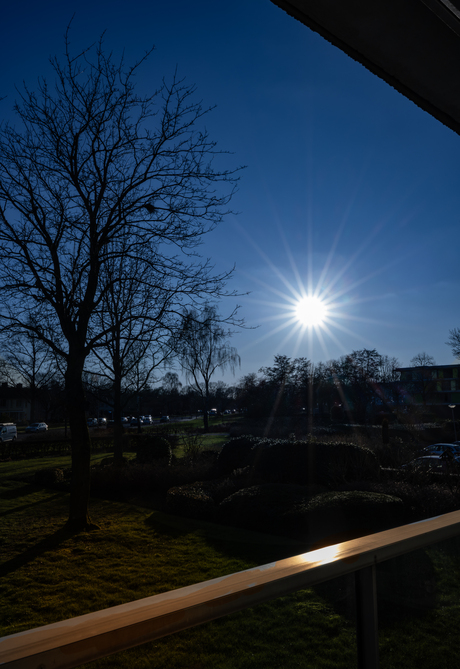 blauwe lucht  en zon op het balkom