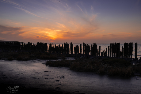 De zon neemt weer kleurrijk afscheid van een mooie dag op het Wad