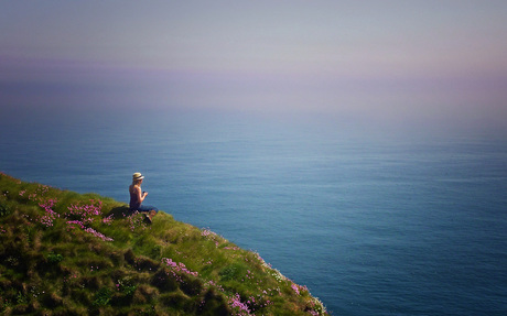 YOUNG WOMAN LOOKING OUT OVER SEA