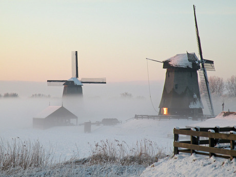 molen in de mist bij sneeuw, zonlicht in raam