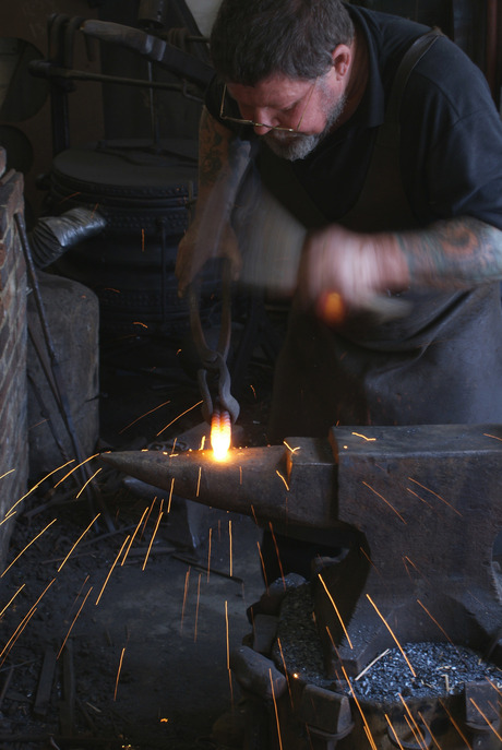 Blacksmith - smid aan het werk in Michelham Priory, Hailsham, Engeland