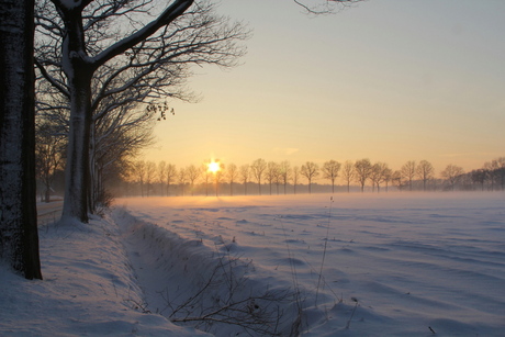 Winterlandschap met zonsdondergang