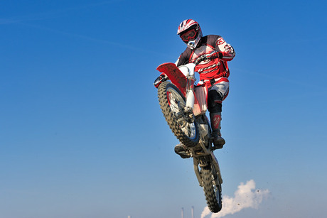 Motorcrossers op maasvlakte in de lucht