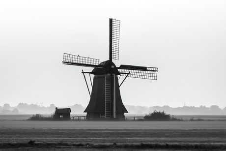 windmill in morning mist across an open landscape