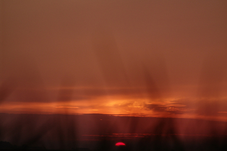 Zonsondergang achter het gras verscholen