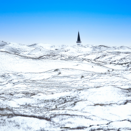 Besneeuwde duinen en het torentje van de kerk van Den Hoorn