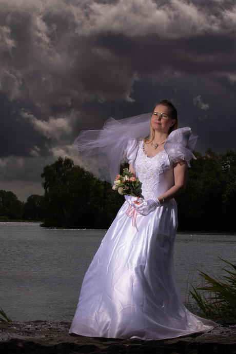 Bruid uitgelicht bij donkere wolken 