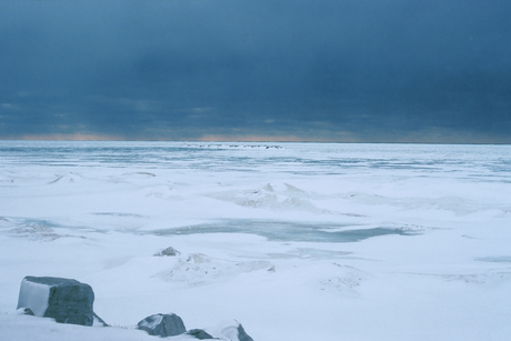 Lake Huron met ijs en donkere wolken