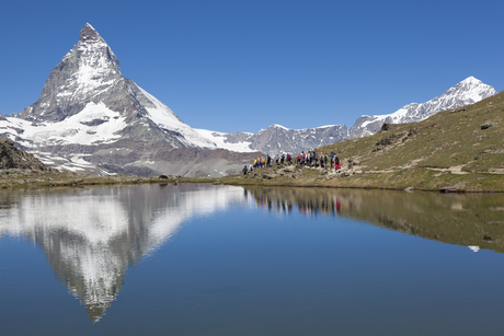 Wandelaars op de oever van de Riffelsee met de Matterhorn op de achtergrond