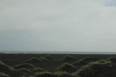 zwart zand groene heuvels