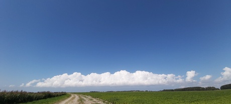 Wolken boven zeedijk.