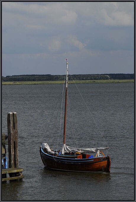 Houten scheepje vaart haven uit