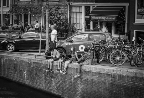 Kinderen chillen aan de gracht in Amsterdam