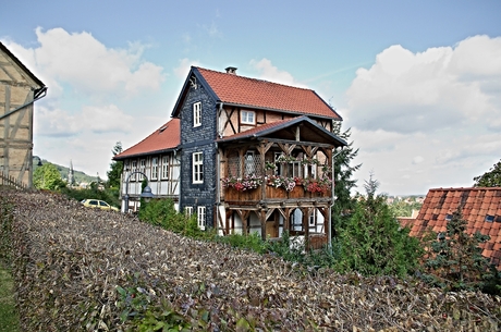 Huis met twee houten balkons boven elkaar.