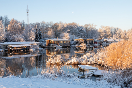 Zonsopkomst bij de woonboten in de sneeuw.