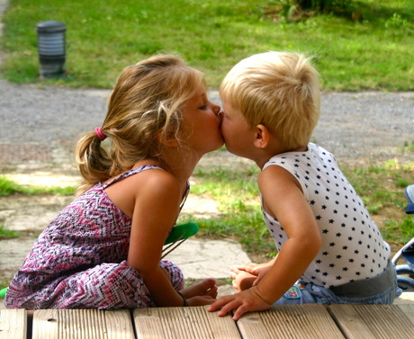 Zus en broer samen knuffelend aan het strand