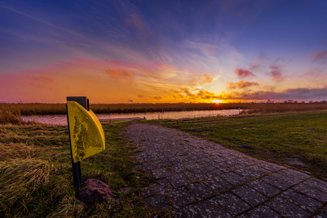 Zonsondergang aan de dijk