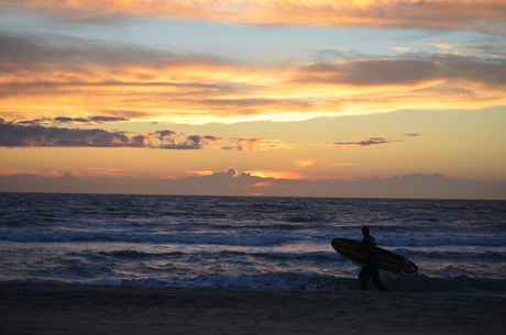 Surfer bij zonsondergang